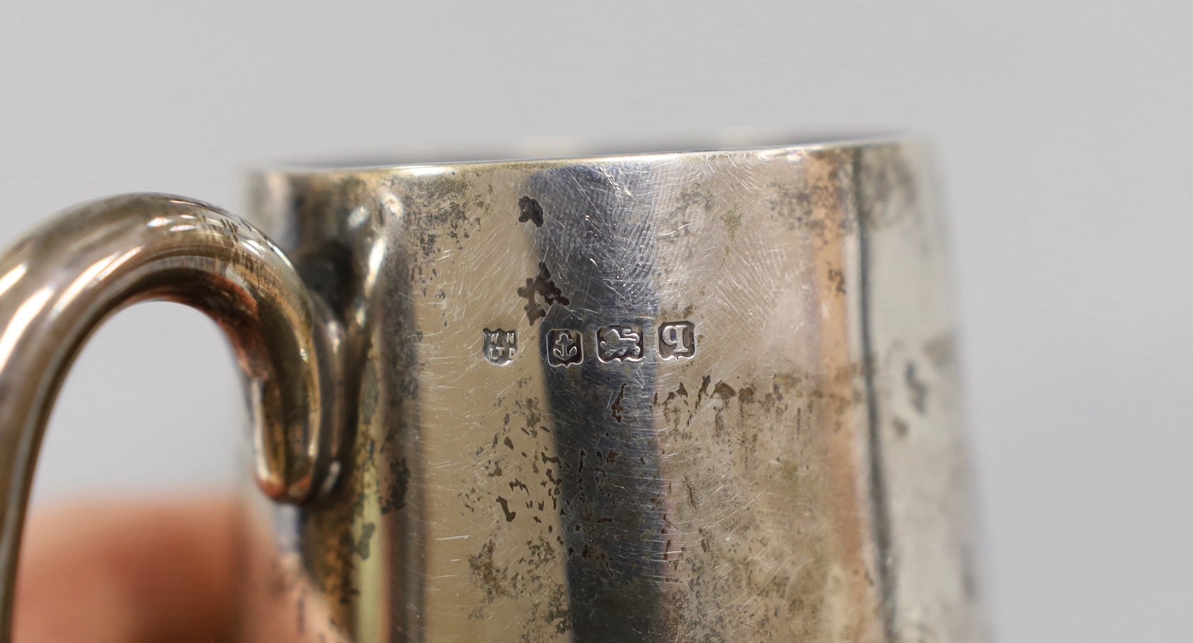 A George III silver inverted pear shaped cream jug, marks rubbed, 72mm and a later silver christening mug.